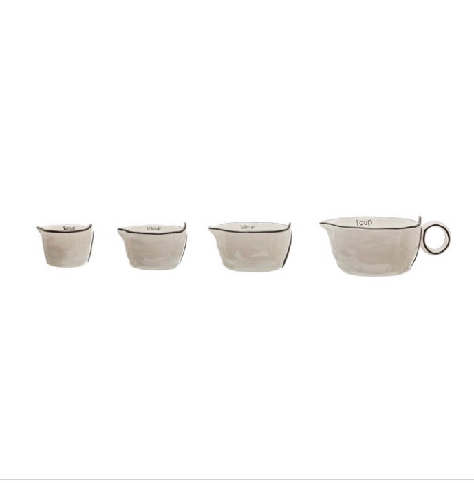 This rustic set of measuring cups are made of stoneware, they are white with a black rim on the edges with a little pour spout. The set looks nice nested together. These measuring cups would make a perfect gift for a home chef or baker.