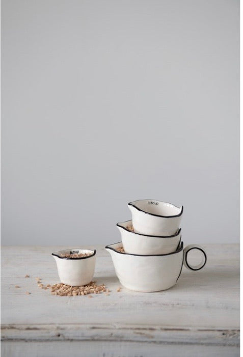 This rustic set of measuring cups are made of stoneware, they are white with a black rim on the edges with a little pour spout.  The set looks nice nested together. These measuring cups would make a perfect gift for a home chef or baker.