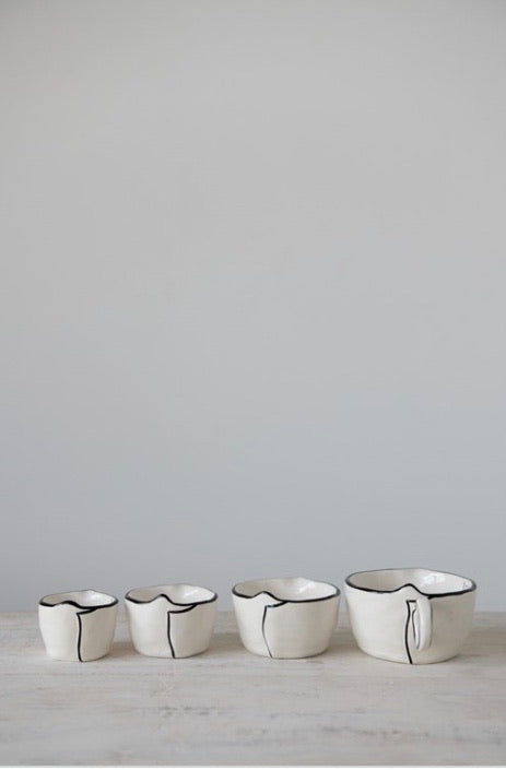 This rustic set of measuring cups are made of stoneware, they are white with a black rim on the edges with a little pour spout.  The set looks nice nested together. These measuring cups would make a perfect gift for a home chef or baker.